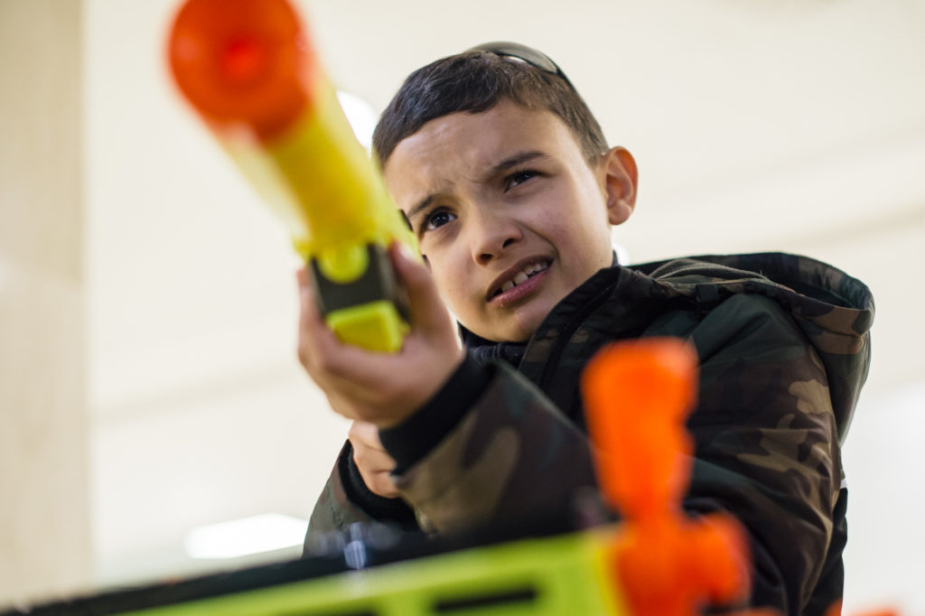 a kid aiming from Nerf toy gun