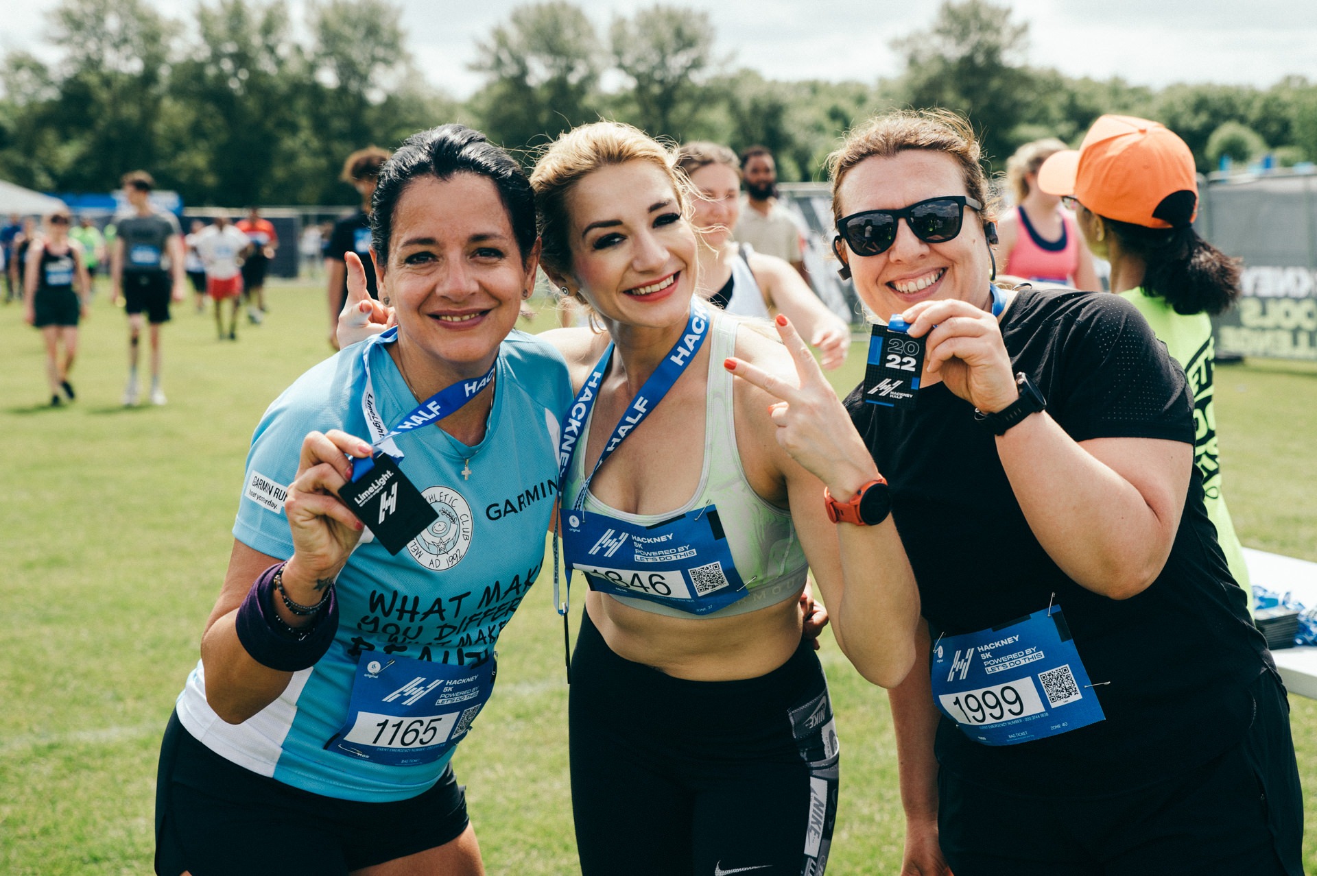 3 ledies posing with hackney marathon medals