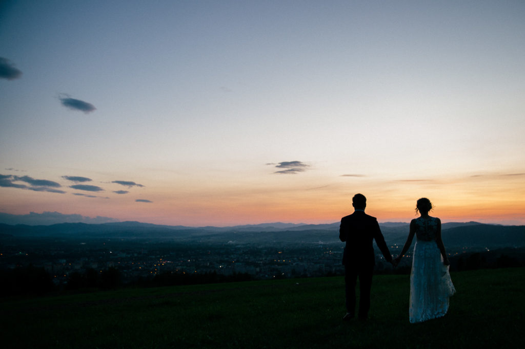 a wedding couple walking towards the sunset